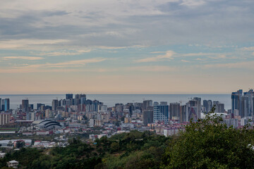 Fototapeta premium Beautiful sunset on the coast. View of the city from the hill. Skyscrapers in the port city.
