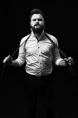 Emotional portrait of a man in a white shirt and an untied tie on a black background. Grain effect used