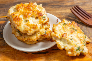 Chicken cutlets or patties for tasty snack on wooden background.