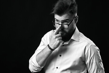 Emotional portrait of a man with a beard in a white shirt and glasses. Grain effect used