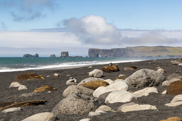 iconic mountain range formations in the distance at the black sand beach called Reynisfjara, Iceland