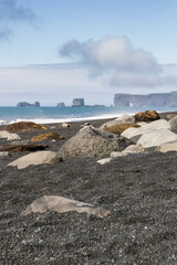 iconic mountain range formations in the distance at the black sand beach called Reynisfjara, Iceland