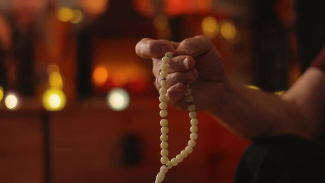 Hand holding a rosary beads or Tasbih, meditation prayer beads