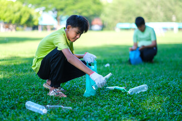 Teenagers picking up water bottles of trash cleaning up school yards and recycling plastic.  Volunteer Asian kid wearing gloves for safety, hot summer holiday.
