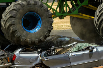 Detail of the wheels of a monster car going up and destroying a sedan car. Conceptual photo of strength, destruction and power. Overcome obstacles to adrenaline victory  © fabrizio maffei