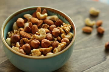 a plate of nuts. a nutritious and healthy snack. A mixture of walnuts, almonds, hazelnuts, cashews. Vegetarian food