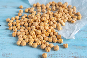 Crispy chickpeas for healthy snack on blue wooden background.