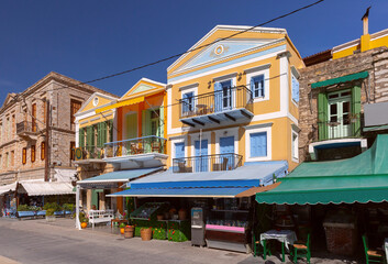 Picturesque row of brightly colored houses along waterfront promenade of Symi Island, Greece