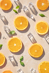 Sliced oranges with ice and mint leaves on a cream background. Summer aesthetic concept.