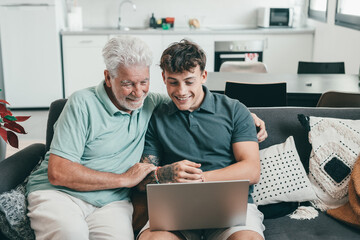 Happy family, grandfather learning new computer technology from experienced young grandson,...