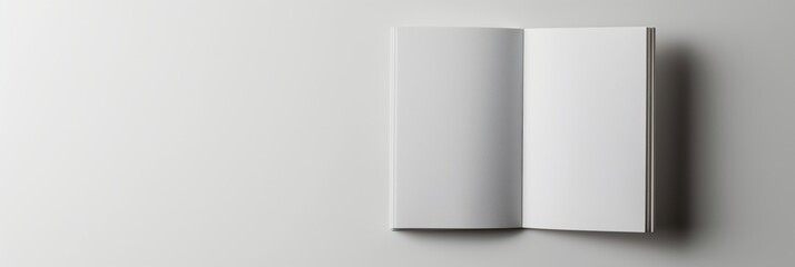 A minimalistic image of an open blank white book on a flat gray background with copy space