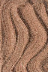 Lines drawn in brown sand background, beautiful sand texture, overhead view of chocolate brown sand, zen pattern drawn in the sand, Top view of fine grain texture
