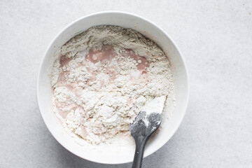 Overhead view of roughly mixed bread dough, flatlay of high hydration bread dough in a white bowl