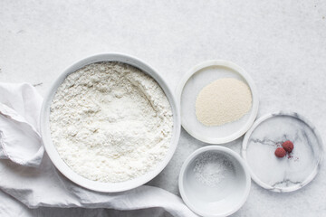 Mise en place of ingredients for making bread, All purpose flour salt and yeast on a marble countertop, process of making bread