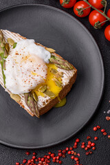 Delicious hearty breakfast consisting of poached eggs on toast with cream cheese, asparagus