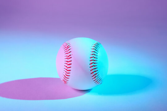Baseball in blue and purple lighting with copy space for sports art or background.
