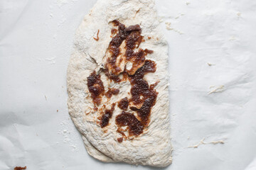 Fototapeta premium Overhead view of date jam on bread dough, flatlay of date jam on sourdough, process of making bread