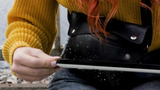 The girl connects a flash drive to her tablet