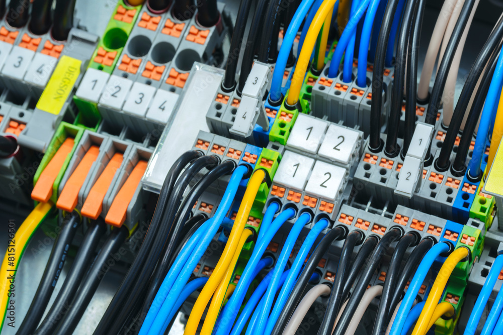 Poster a bunch of wires are connected to a box with yellow and black labels