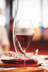 A wine glass with a red liquid in it is on a table
