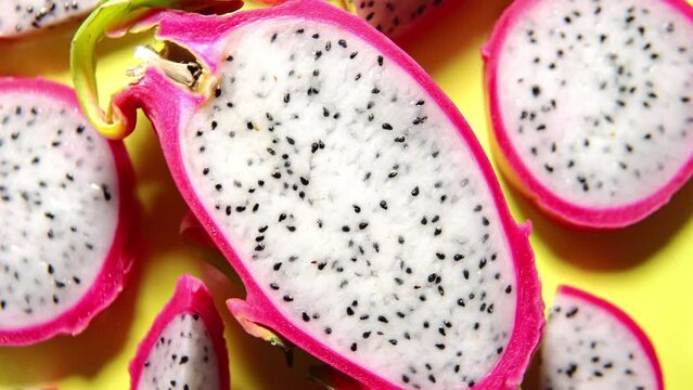 Slices of fresh white pitaya or dragon fruit on yellow background, flat lay. Concept of exotic tropical and vegan food. 360 degrees rotation