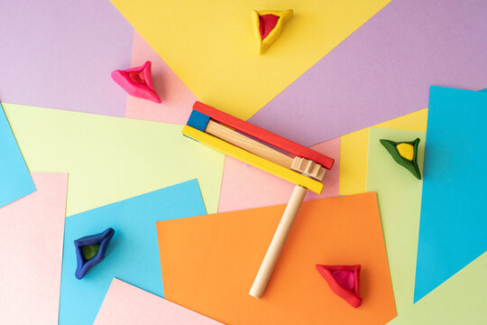 Colorful background with traditional decoration noisemaker and sweet cookies Hamantaschen for Jewish holiday Purim.