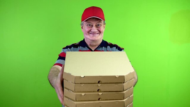 Mature delivery man hands pizza boxes to customer and smiles.