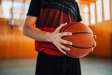 Naklejka premium Unrecognizable caucasian male basketball player with a ball in his hands