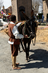Hombre con su burro en feria medieval.
