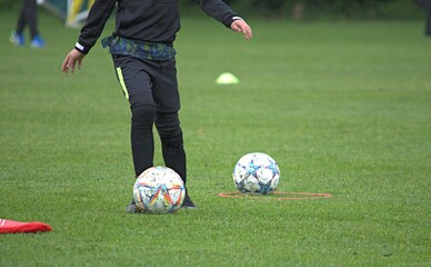 boy in black sportswear on a football field with a ball