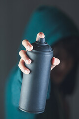 A person is holding a spray can in their hand