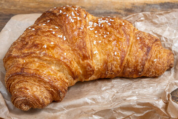 Fresh croissant on paper background. Morning food.