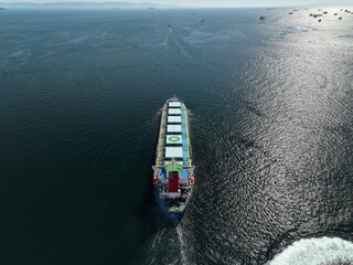 A large ship is sailing in the ocean. trade cargo ship aerial view