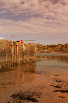 Harbour sea wall at Porth Nefyn, Gwynedd, North Wales. Taken at low tide in evening sunlight