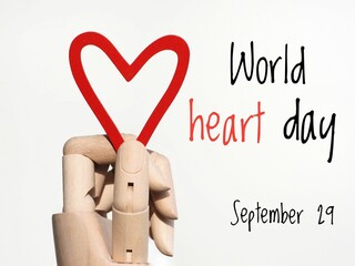 World heart day September 29 poster. A hand holding a red heart and text on a white background 