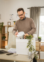 Adult unhappy man pack his stuff at office after he fired from job