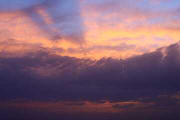 a sunset sky with clouds and a purple sky with a few clouds.
