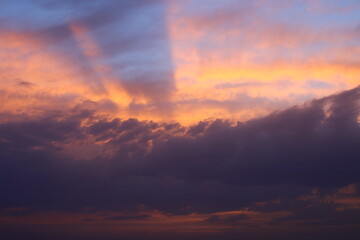 a sunset sky with clouds and a purple sky with a few clouds.