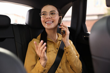 Woman with seatbelt talking on phone inside car