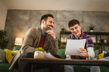 Adult professor mentor and young student read together lesson at home