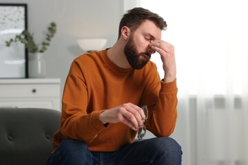 Overwhelmed man with glasses suffering at home