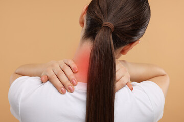 Fototapeta premium Woman suffering from neck pain on dark beige background, back view