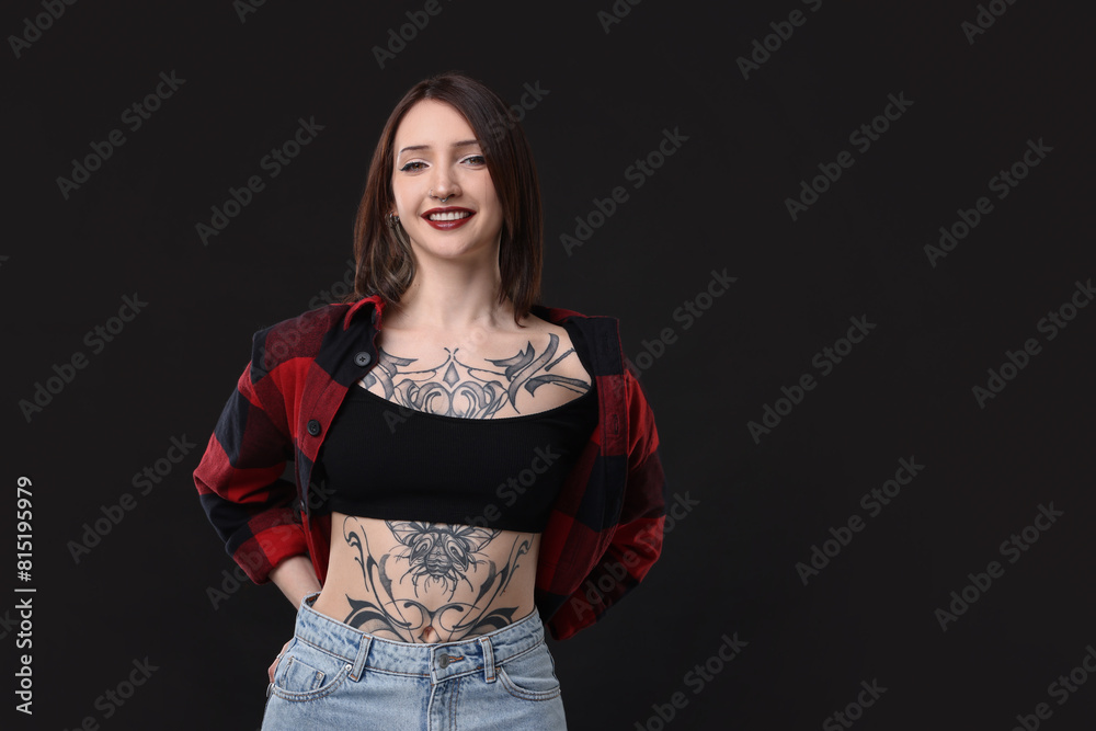 Poster Portrait of smiling tattooed woman on black background. Space for text