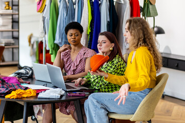 Concept of diversity, teamwork, women doing project together. Group of young females, university students working on fashion startup, online clothes resale. Small business, African American, caucasian