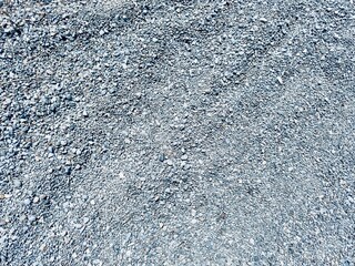 A detailed view of a gravel pile composed of crushed rock, showcasing its rugged texture and...