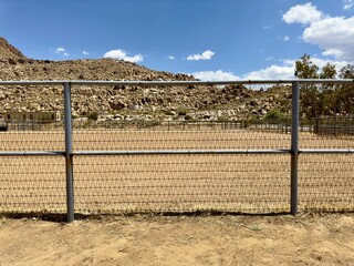 Wild West horse stable corral features rugged wood fencing, dusty trails, rustic barns, and sturdy...