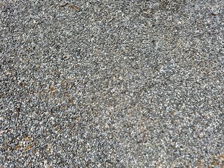 A close-up view of an old, weathered asphalt road surface, showcasing its cracked, rugged texture and faded lines, telling the story of countless journeys and the passage of time.