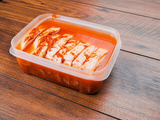 Pork chops in red Asian style marinade with chilly pepper in plastic container. Fine pork meat for grill or summer barbecue. Popular dish with rich flavor.