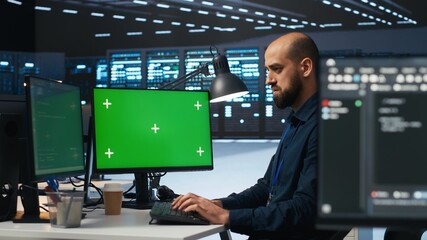 Technician overseeing server room, running code on green screen computer, troubleshooting servers....