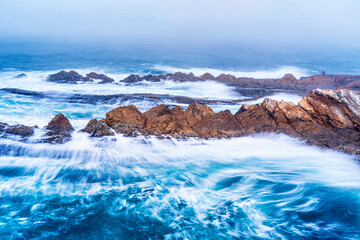 Waves crashing into rocks at the ocean